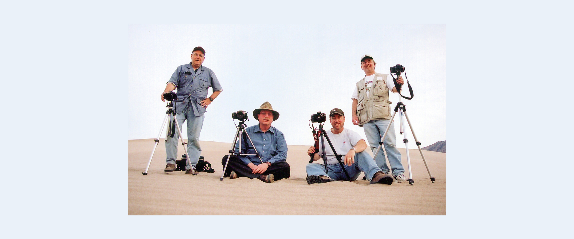 David Pincus (standing), Stephen Wood (sitting), Bruce Burtch (sitting), and Rick Knapp (standing) all with cameras on tripods on a dune.